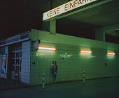 Woman standing on petrol station at night
