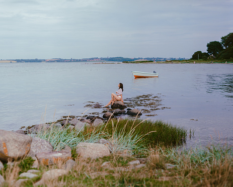Young Caucasian woman sitting on the Falckenstein Beach in Germany
