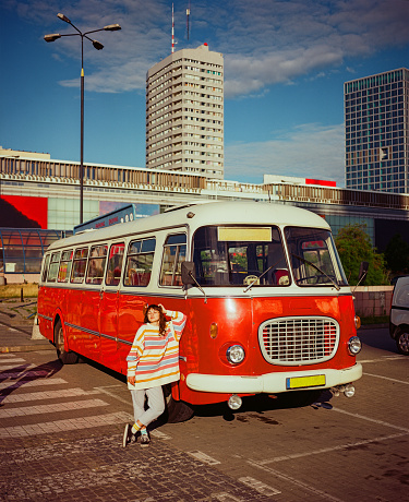 Woman standing  near vintage red van in  Warsaw