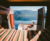 Woman resting near the camper van  near the lake in Norway