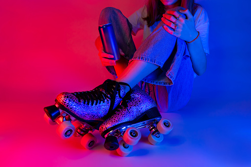 Roller skater holding a soda drink in a can during rest. Skating - sports and recreation. Saturated pink and blue, pop art style poster.