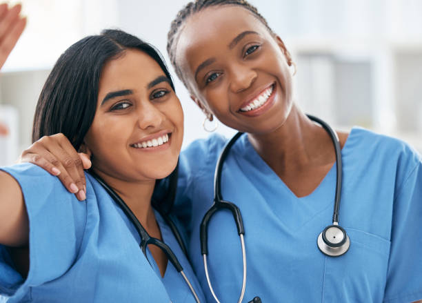doctors, selfie and women friends at hospital smile for photograph together with stethoscope. happy, healthcare and interracial friendship picture of professional cardiology workers on break. - nurse imagens e fotografias de stock