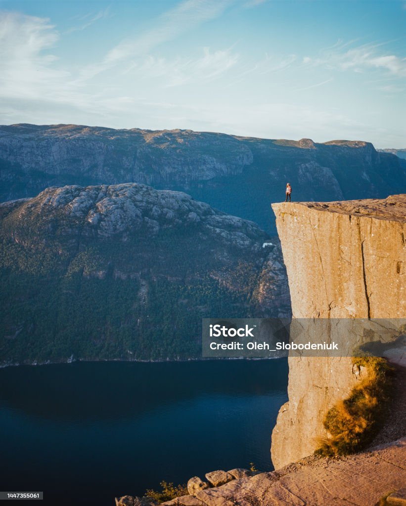 Woman standing on Preikestolen and looking at view Young Caucasian woman standing on Preikestolen and looking at view Norway Stock Photo