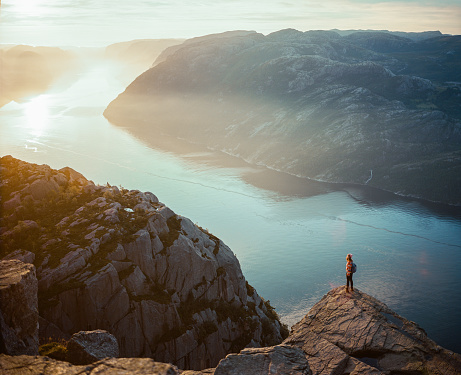 Mujer caminando en las montañas en el fondo de Lysefjorden photo
