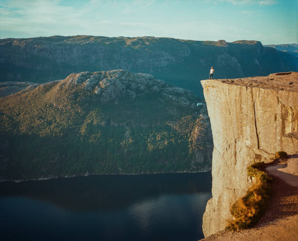 istock Man standing on Preikestolen and looking at view 1447355096