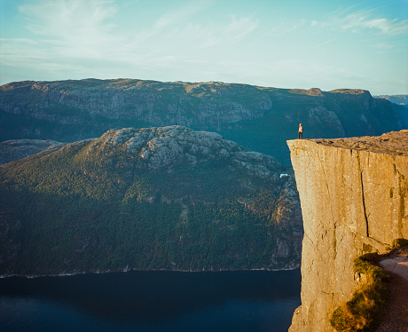 Young Caucasian woman standing on Preikestolen and looking at view
