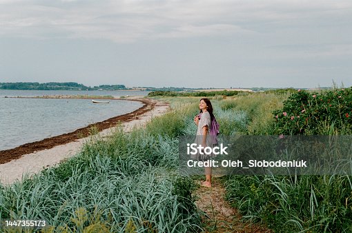 istock Woman walking near the sea in Germany 1447355173