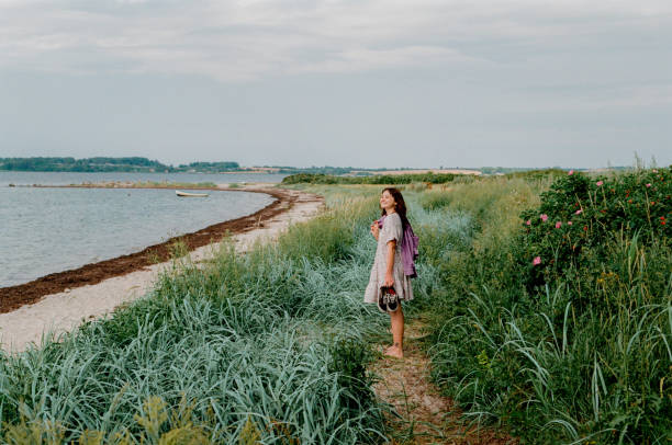 Woman walking near the sea in Germany Young Caucasian woman walking on the Falckenstein Beach in Germany baltic sea people stock pictures, royalty-free photos & images