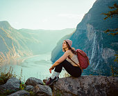 Woman sitting near Seven sisters  waterfall in mountains in Norway
