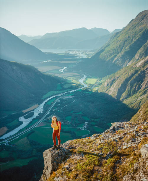 istock Woman standing on cliff and looking at river valley 1447355514