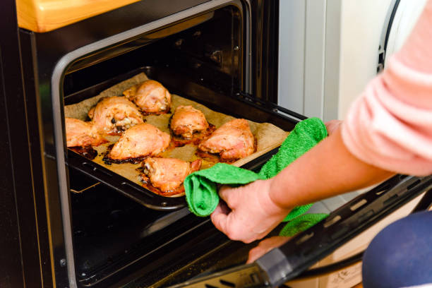 istock Fried chicken meat, woman hand pull up baking dish from the oven.festive dinner,view from above. Close-up. Selective focus. 1447358016