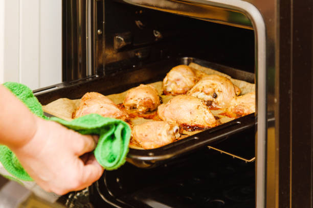 istock Fried chicken meat, woman hand pull up baking dish from the oven.festive dinner,view from above. Close-up. Selective focus. 1447358021