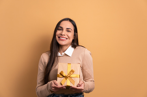 Smiling woman showing Christmas gift box