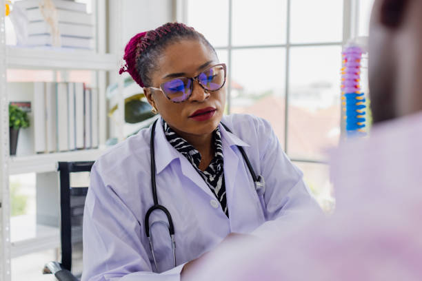 istock Black doctor with patient in doctor office. 1447358361