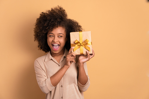 Cheerful woman holding gift box