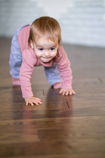 istock Baby girl crawling at home 1447360501