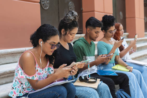 istock Small group of university students using their smartphones outdoors 1447362755