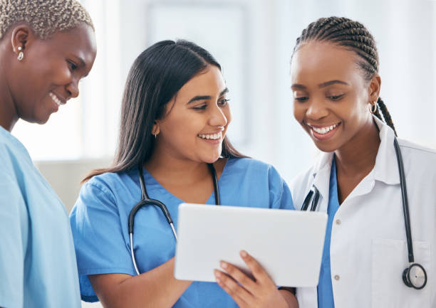 istock Happy women doctors, digital tablet or teamwork, planning or collaboration staff working online, technology ir support in hospital. Healthcare group consulting medical research on internet connection 1447362978