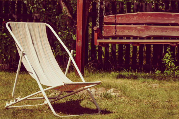 istock Garden with deck chair and swing 1447363257