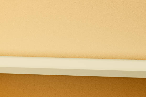 istock yellow empty shelf on yellow orange stucco wall. 1447365970