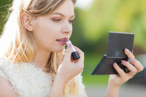 istock Woman applying red lipstick 1447366296