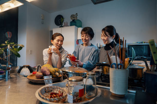 istock Three mature women looking at a smart phone in a kitchen 1447366552
