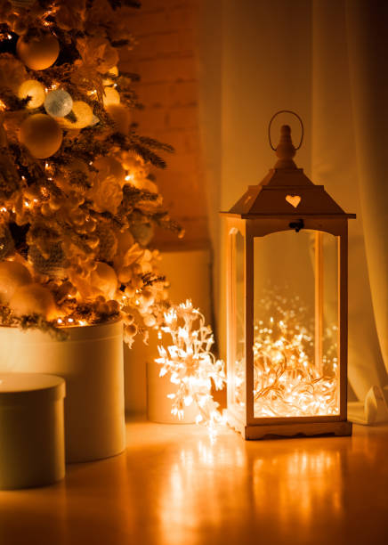 istock Lantern, candlestick in retro style stands on the floor. Inside is a Christmas garland. Photography in warm golden tones, night 1447368982