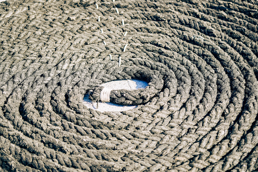 Twisted gray rope on a boat deck.