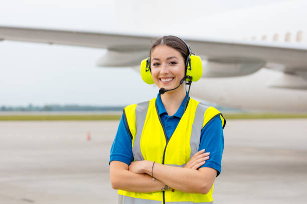 servicio de tierra en el aeropuerto, mujer frente al avión - arms crossed audio fotografías e imágenes de stock