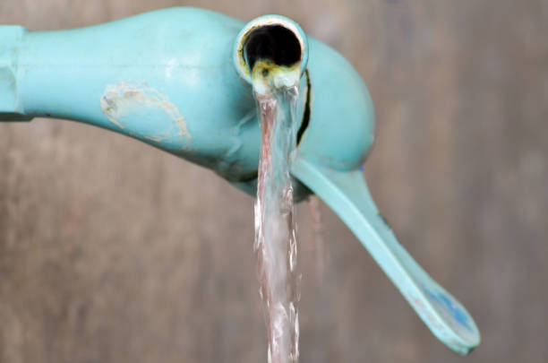 close up  an old light blue plastic faucet in a blurry kitchen