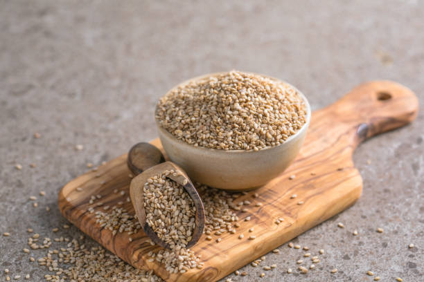 istock Sesame seeds in a little bowl on stone background. top view. 1447384885