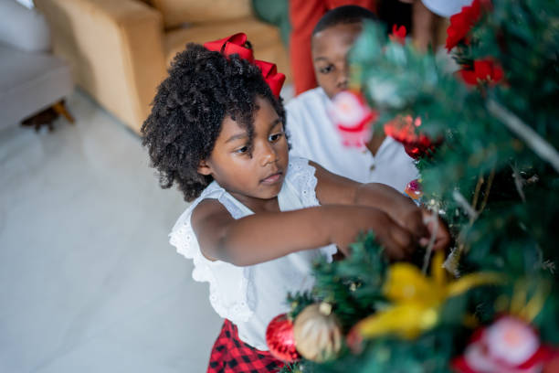 istock Father and daughter decorating Christmas tree 1447386411