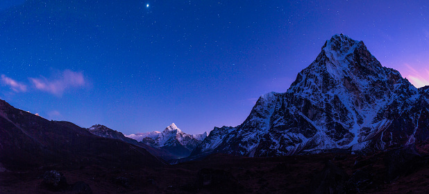 Stars shining over the snow capped peak of Ama Dablam and the north face of Cholatse deep in the Himalaya mountains of Nepal.