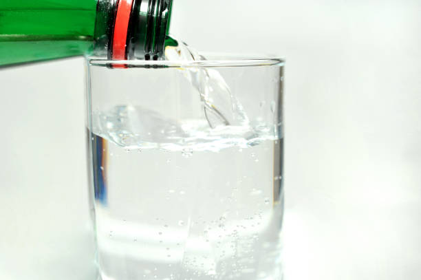 istock Bottled mineral water and a glass on a white background 1447386735