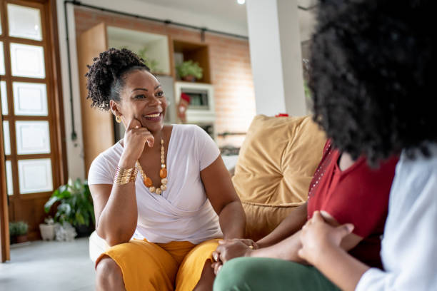 istock Mom and her two daughters sitting on the couch at Christmas talking 1447386776
