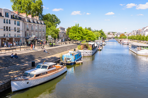 Nantes, France - September 19, 2022: General view of the Erdre river with houseboats and pleasure boats moored at dock on a sunny summer day.