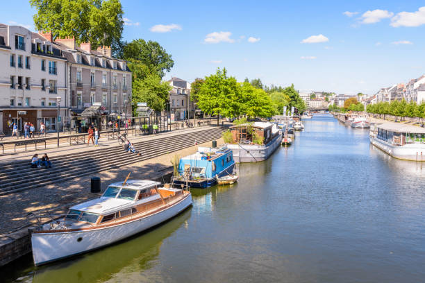 Houseboats and pleasure boats moored on the Erdre river in Nantes, France. Nantes, France - September 19, 2022: General view of the Erdre river with houseboats and pleasure boats moored at dock on a sunny summer day. nantes stock pictures, royalty-free photos & images