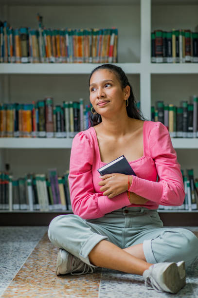 istock young university student in the library reading a book, student doing research at the library 1447396596