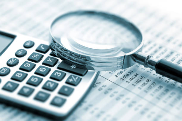 magnifying glass on financial chart - tax financial figures analyzing banking document imagens e fotografias de stock