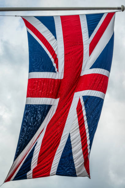 British UK flag on a pole floating in the wind stock photo