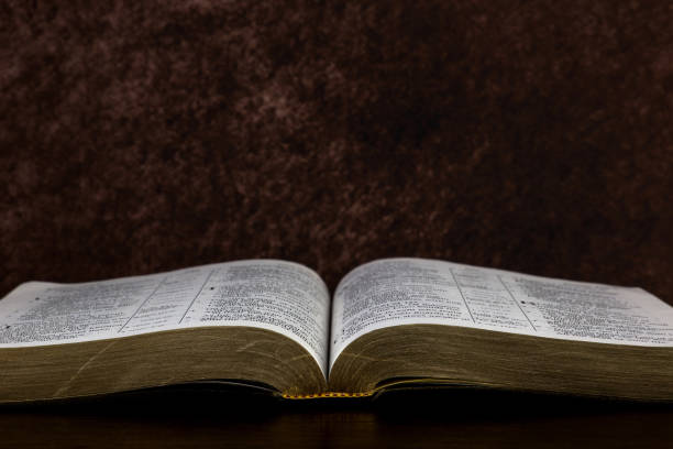 istock Open Christian Bible on a Polished Wooden Surface 1447399331