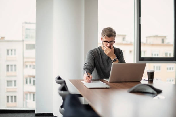 istock Middle aged businessman using laptop at the office 1447399758
