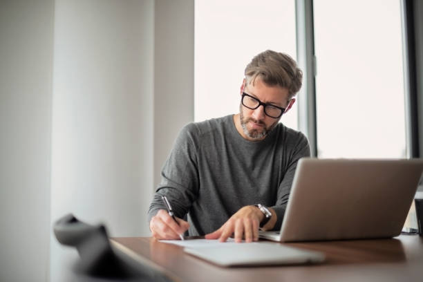 istock Middle aged businessman using laptop at the office 1447399760