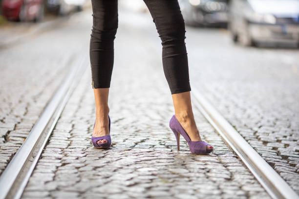 istock woman's legs with purple high heel shoes 1447399867
