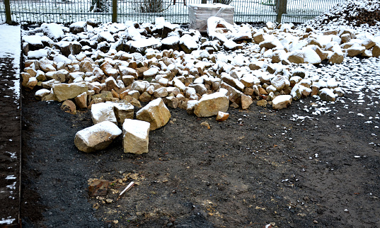 stone pavement just laid dry in the gravel backfill between two sheet steel curbs. sandstone and pieces of burnt brick with a rustic feel. narrow park paths in the herb garden, soil, cultivation, dry wall, layer, geotextile, classify, categorize, perennial garden, workspace, detail, snow, covered, avalanche, snowing, cold, pot, flowerpot