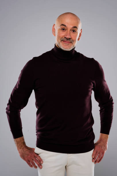 istock Studio portrait of handsome middle aged man wearing turtleneck sweater while standing at isolated background 1447400730