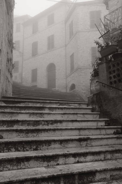Medieval village immersed in the fog with a staircase heading up
