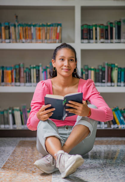 istock young university student in the library reading a book, student doing research at the library 1447400824