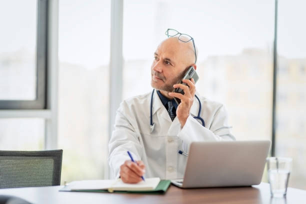 istock Male doctor using laptop while working in doctor's room 1447401303