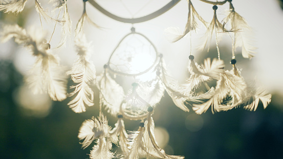 Tribal dreamcatcher hanging from a window. Moving on the wind.